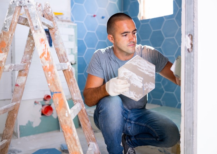 Man installing bathroom tiles