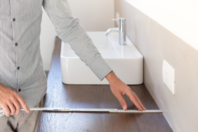 Person sketching a layout for a bathroom renovation