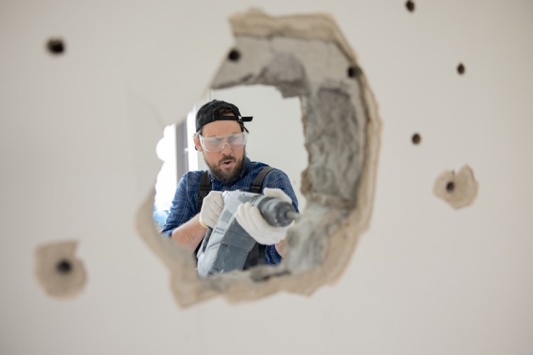 Worker drill a wall during home renovation project