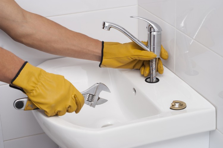 Plumber installs new faucet sink in bathroom